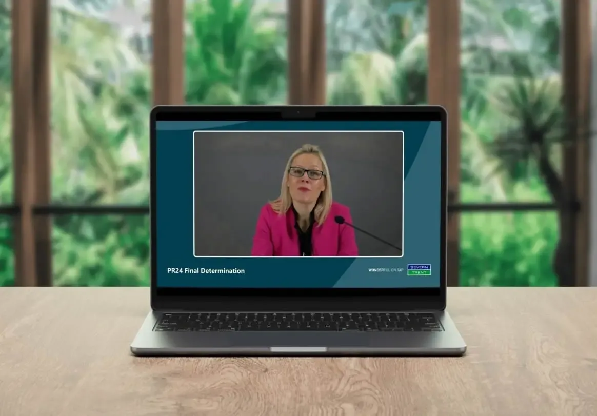Shareholder meeting webcast streamed to a laptop with executive presenter